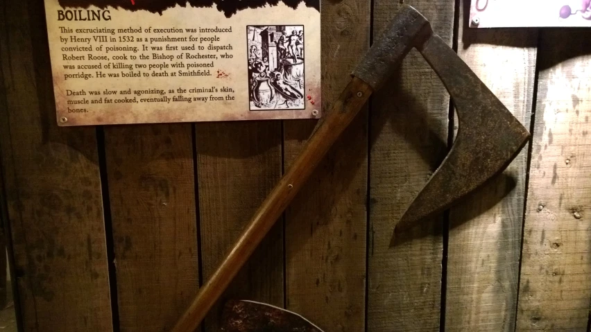 an old rusty axe and a sign in a wooden shed