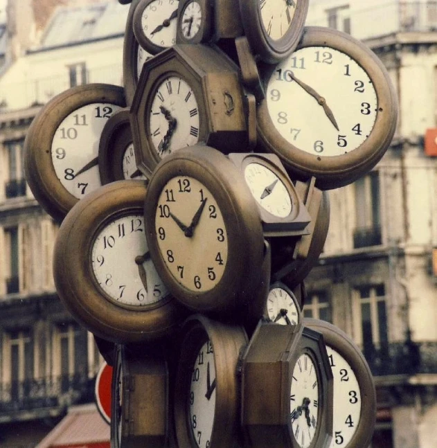 a large group of clocks with faces sitting on top of each other