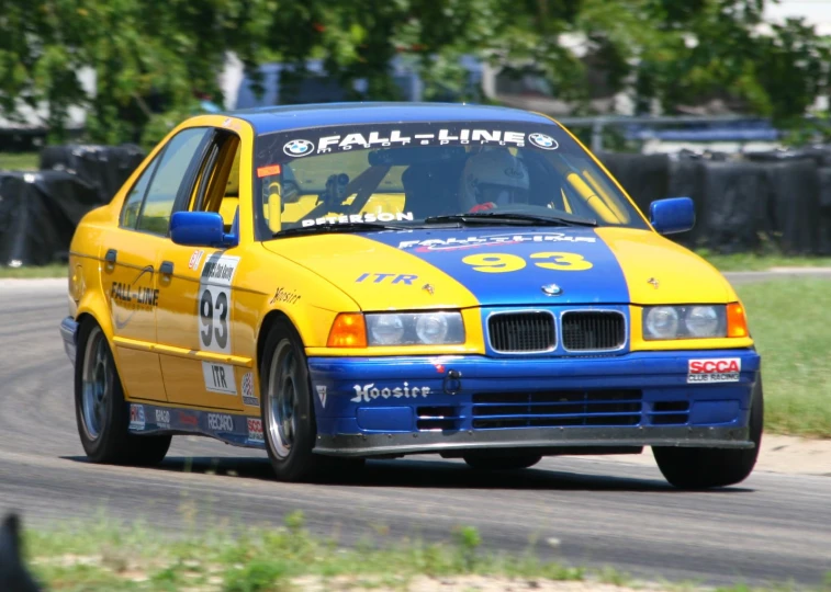 a yellow and blue race car driving on a track