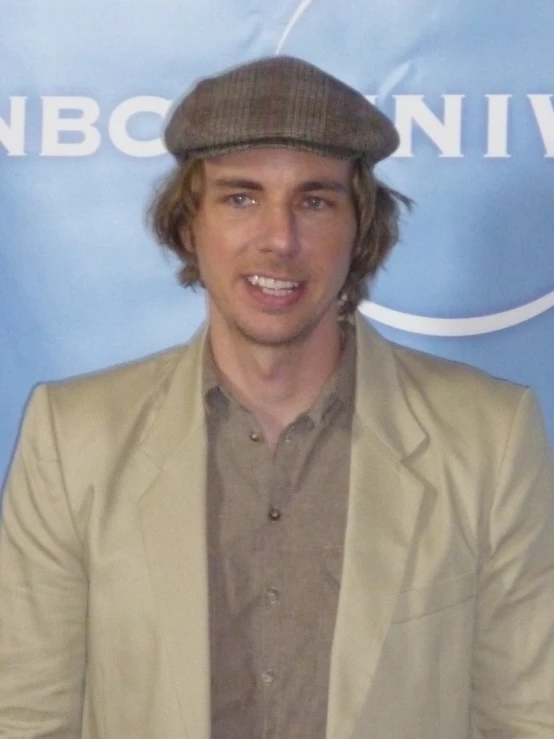 man wearing brown suit and brown hat smiling for camera