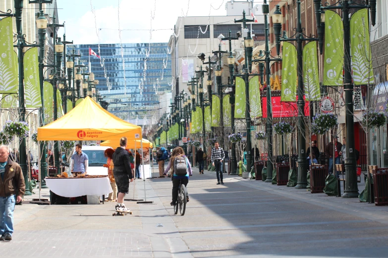 people walking, biking, and riding bicycles down a sidewalk