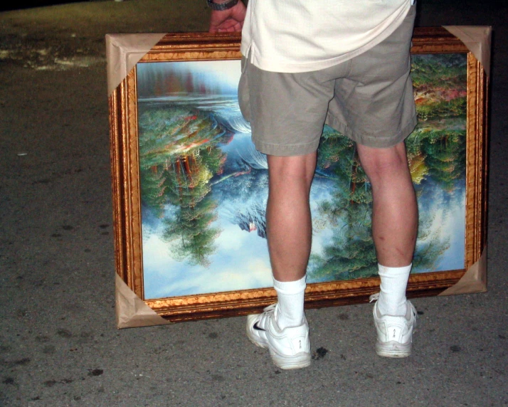 a man with a canvas on a street holding a suitcase
