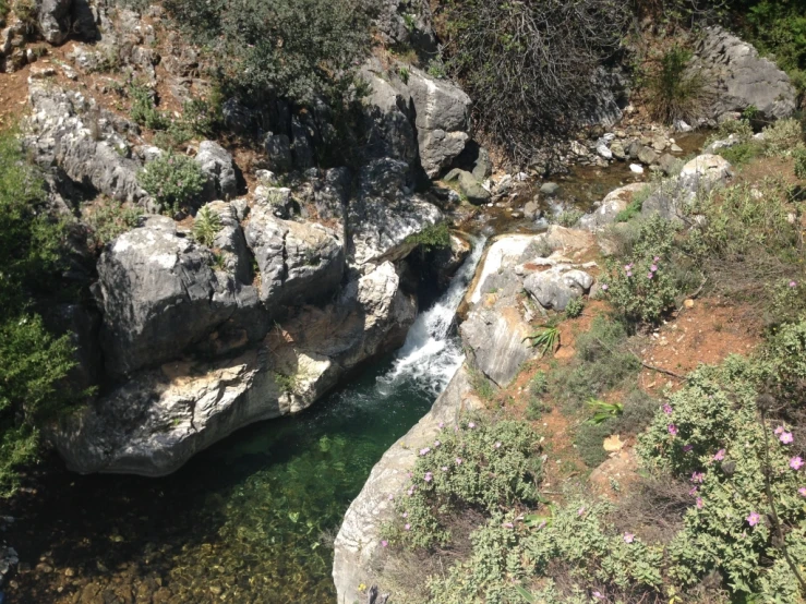 a waterfall flowing through a valley surrounded by rocky mountains