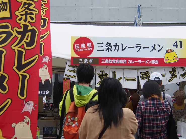 a crowd of people walking around in front of signs