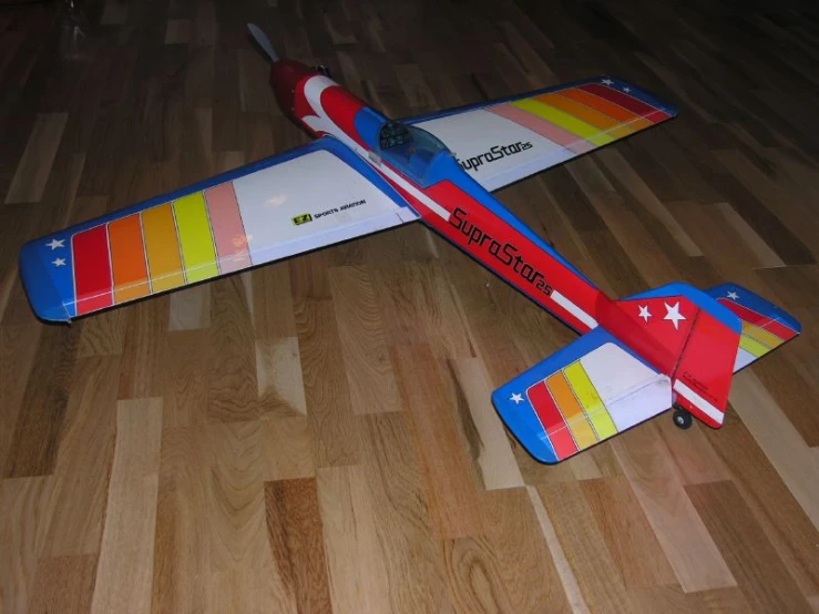 an airplane is laying on the floor on the wooden floor