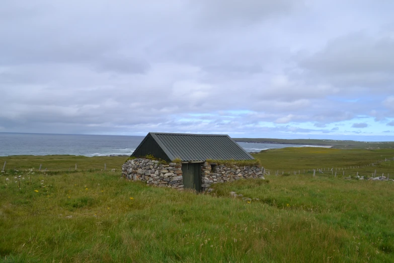 an old, outhouse in a grassy field