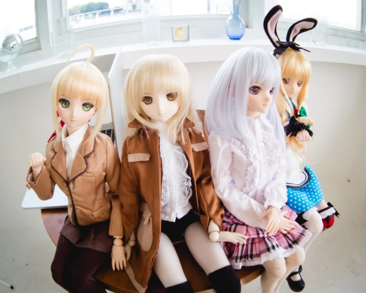 five dolls sit on a chair with their hair down