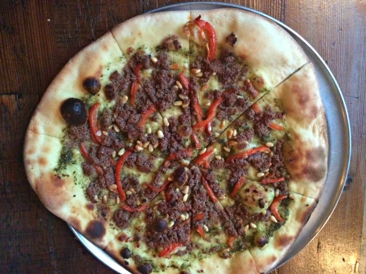 a pizza sitting on top of a pan covered in meat and vegetables