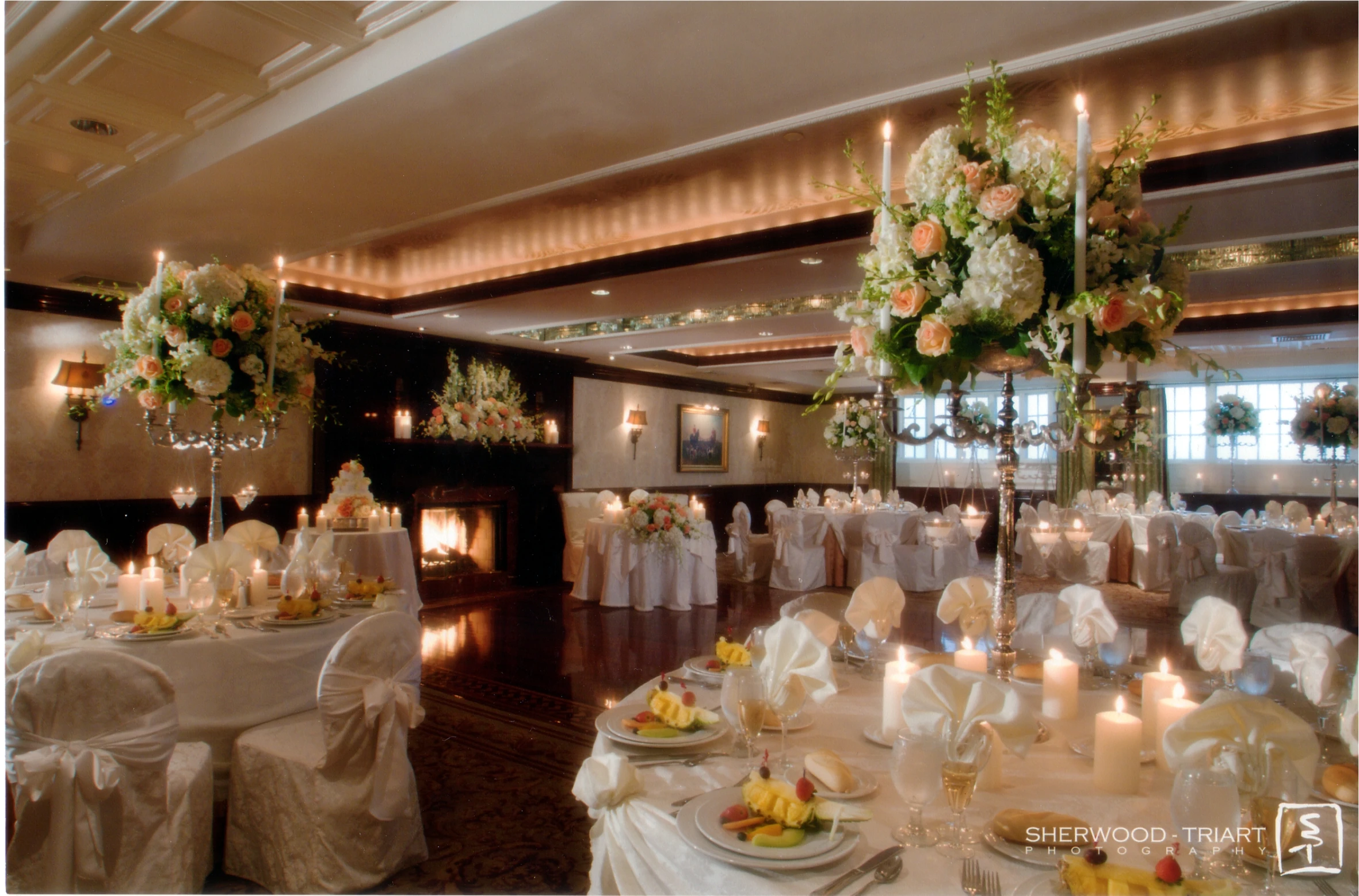 a table with white tables cloths and flowers on them