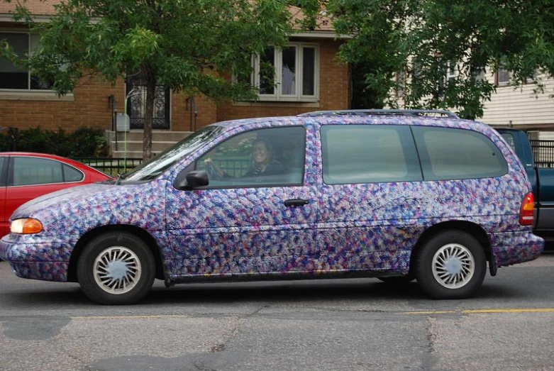 a colorful minivan with an elaborate paint job parked on the street