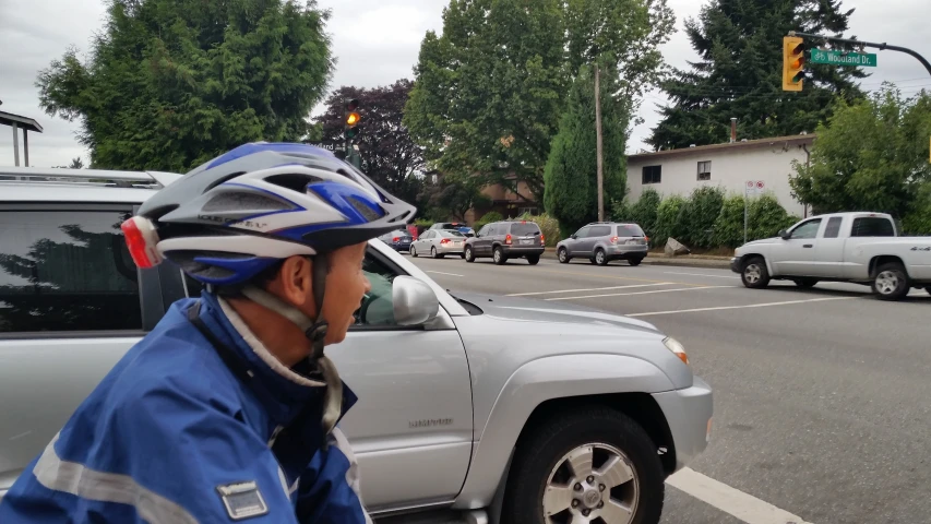 a man with a helmet looks at the street traffic