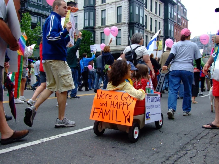 a child on a trailer with a sign on the road