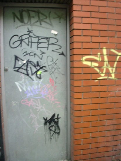graffiti written on a door on the side of a building
