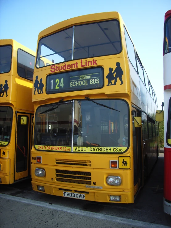 two double decker busses are in a parking lot