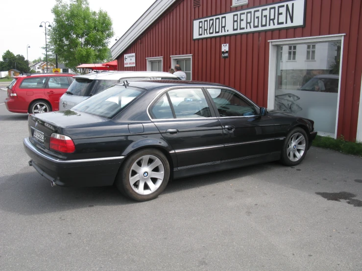 a car sits parked in front of a red building