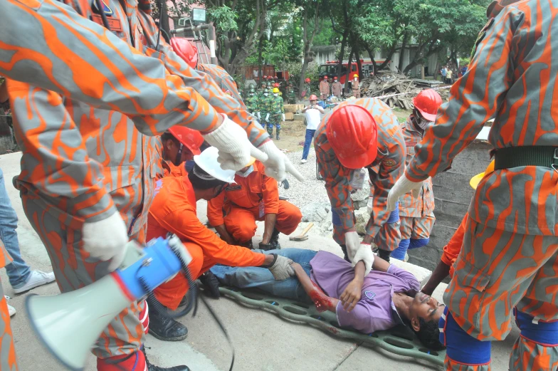 a group of people dressed in orange outfits with one on the ground