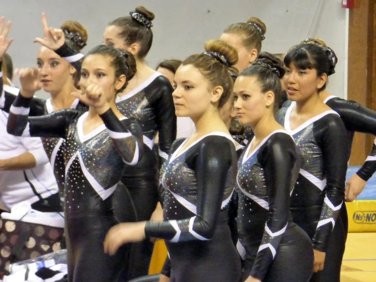 several s doing gymnastics with their hands in the air