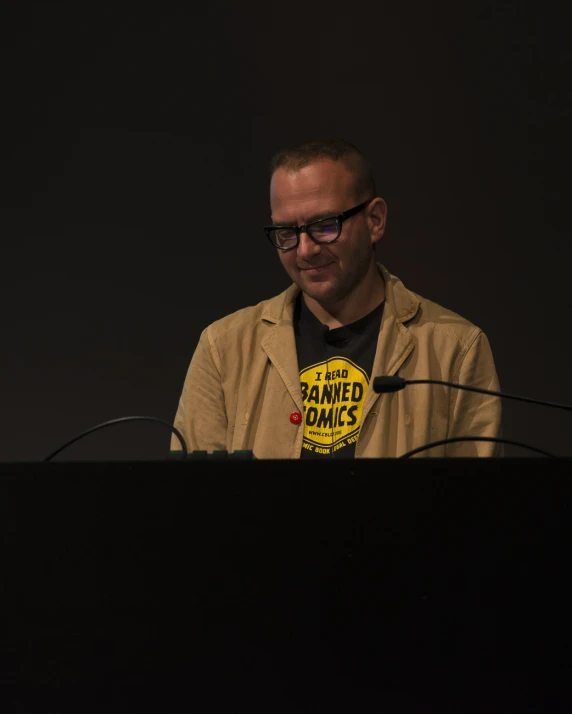 a person wearing glasses and a badge with a name on it