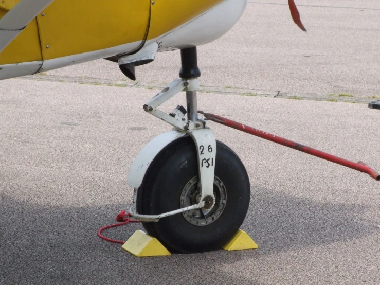 a yellow airplane with its landing gear down on the runway