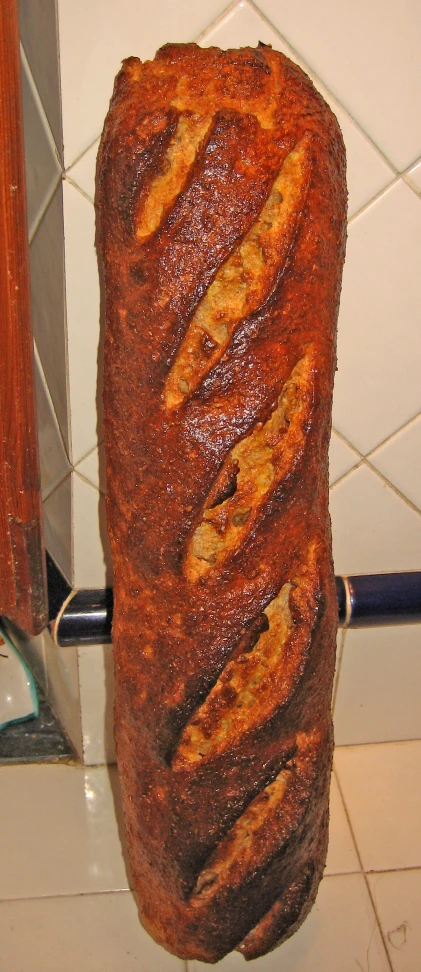 a large loaf of bread sitting on top of a tiled wall