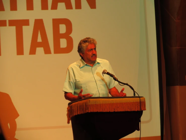 a man standing at a podium with a microphone