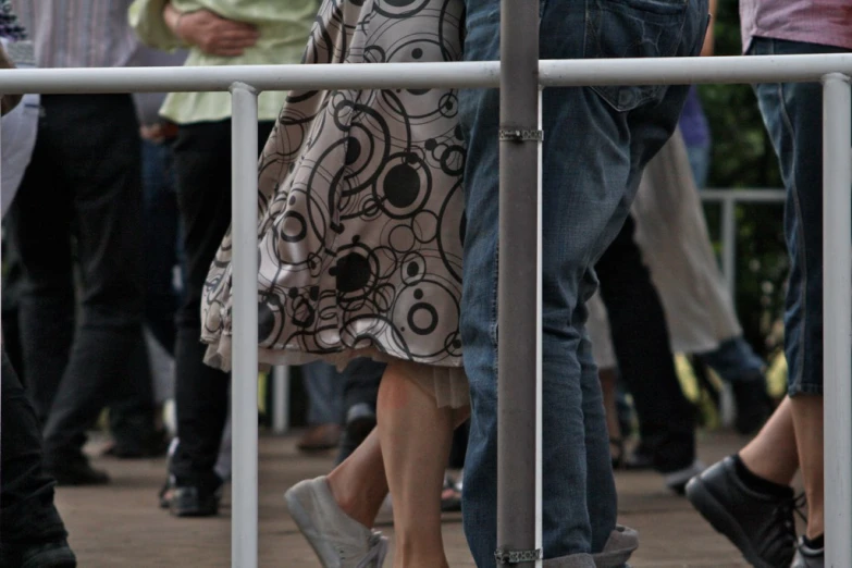 people walking by each other near a fence