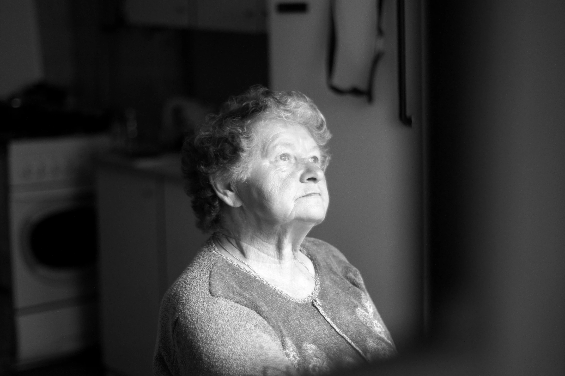 an elderly woman is staring out the window