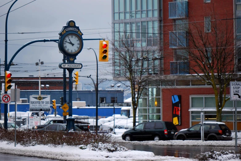 some cars parked near the stoplight and traffic signal on the road