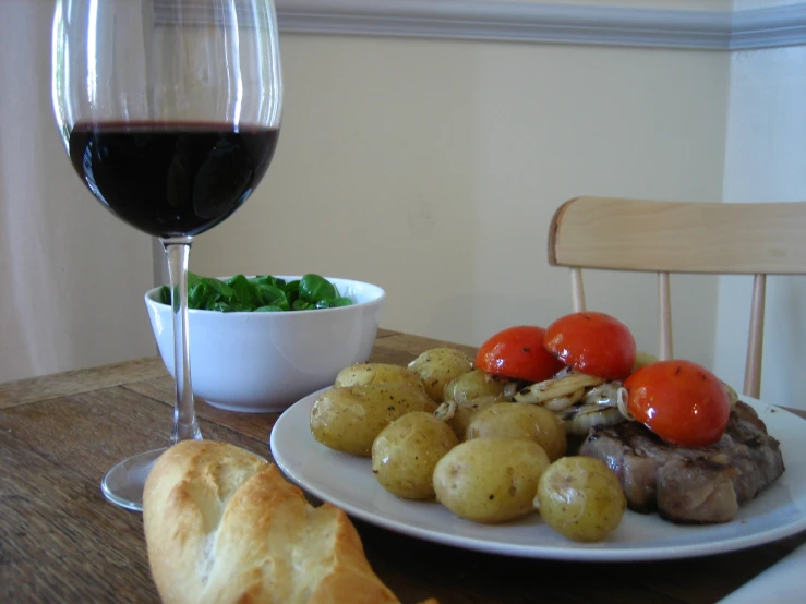 a plate of food and a wine glass on a table