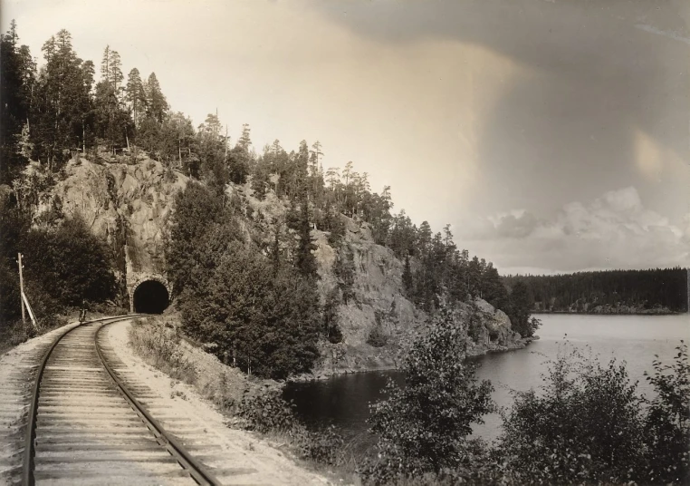 an old po shows a train coming up the tracks near a body of water