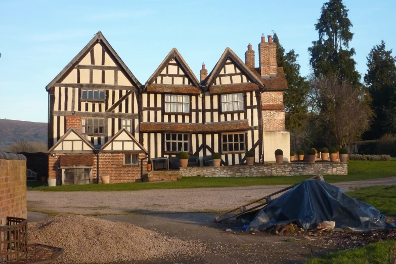 a house with many windows, and a blue tarp in front