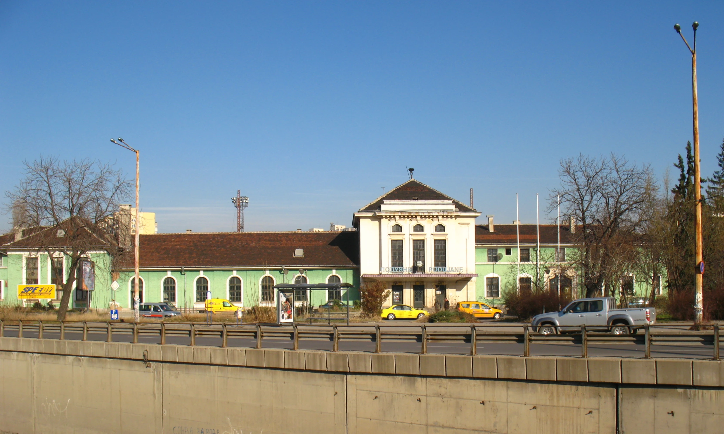 a light blue building with cars on the road