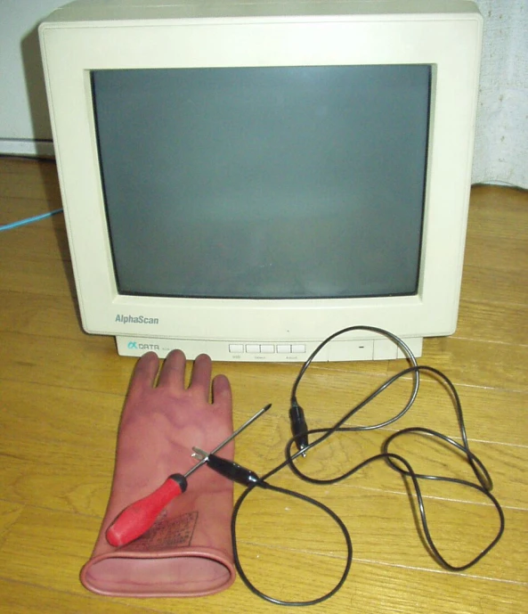 someone has a pair of scissors and is laying on the floor near a computer monitor