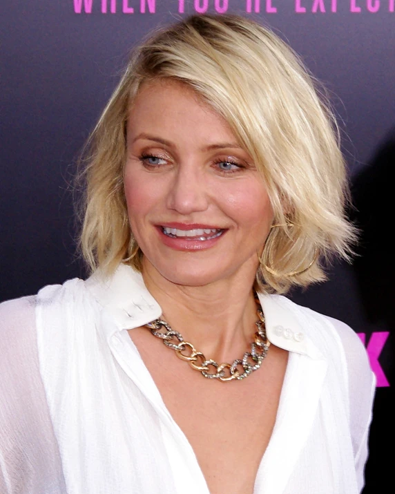 woman with blonde hair and large necklace smiling