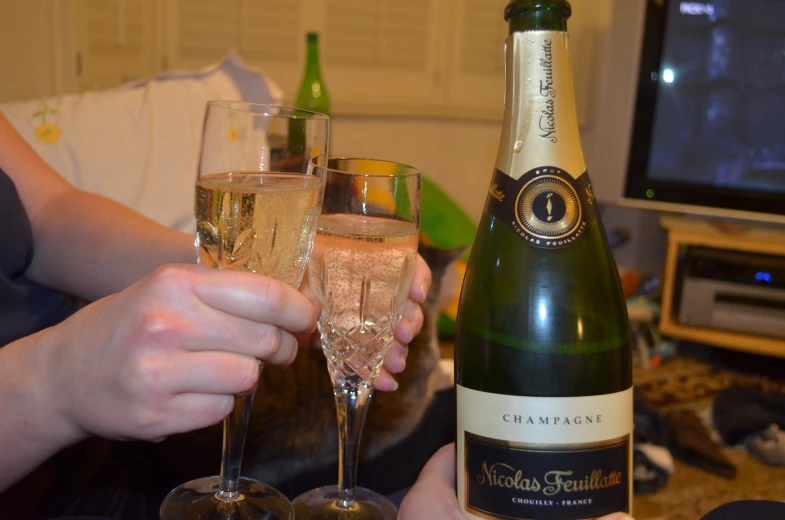 several glasses of champagne on a table next to a television
