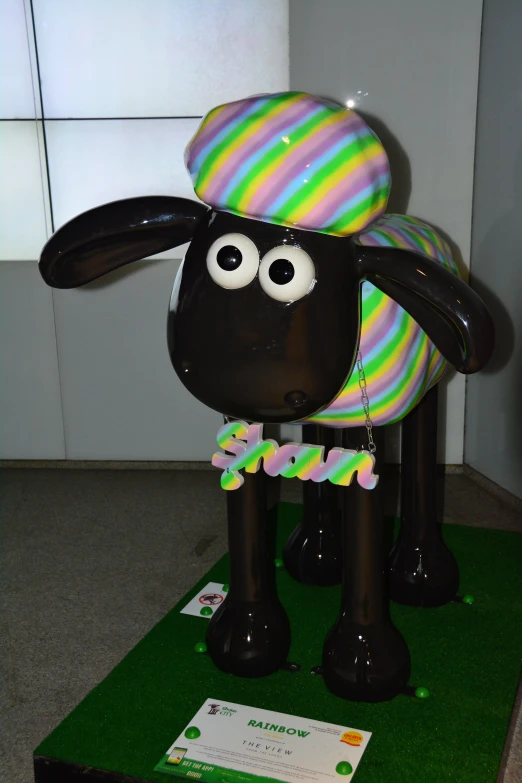 the large sculpture of a sheep has a hat on its head