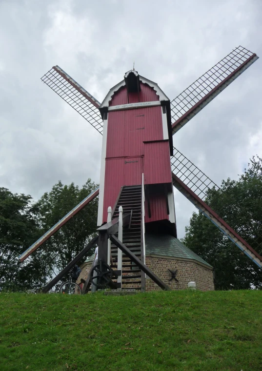 an old mill sits in the middle of a field