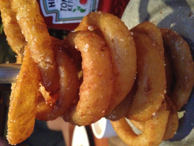 a stack of fried onion rings with ketchup