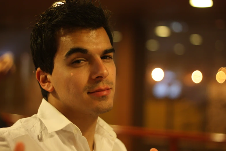 a man in a white shirt and a brown tie looking at the camera