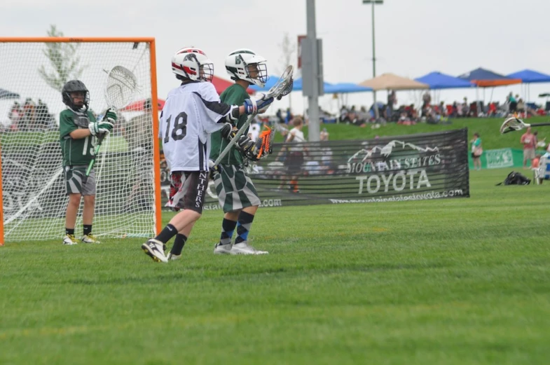 several people on a field playing with a lacrosse ball