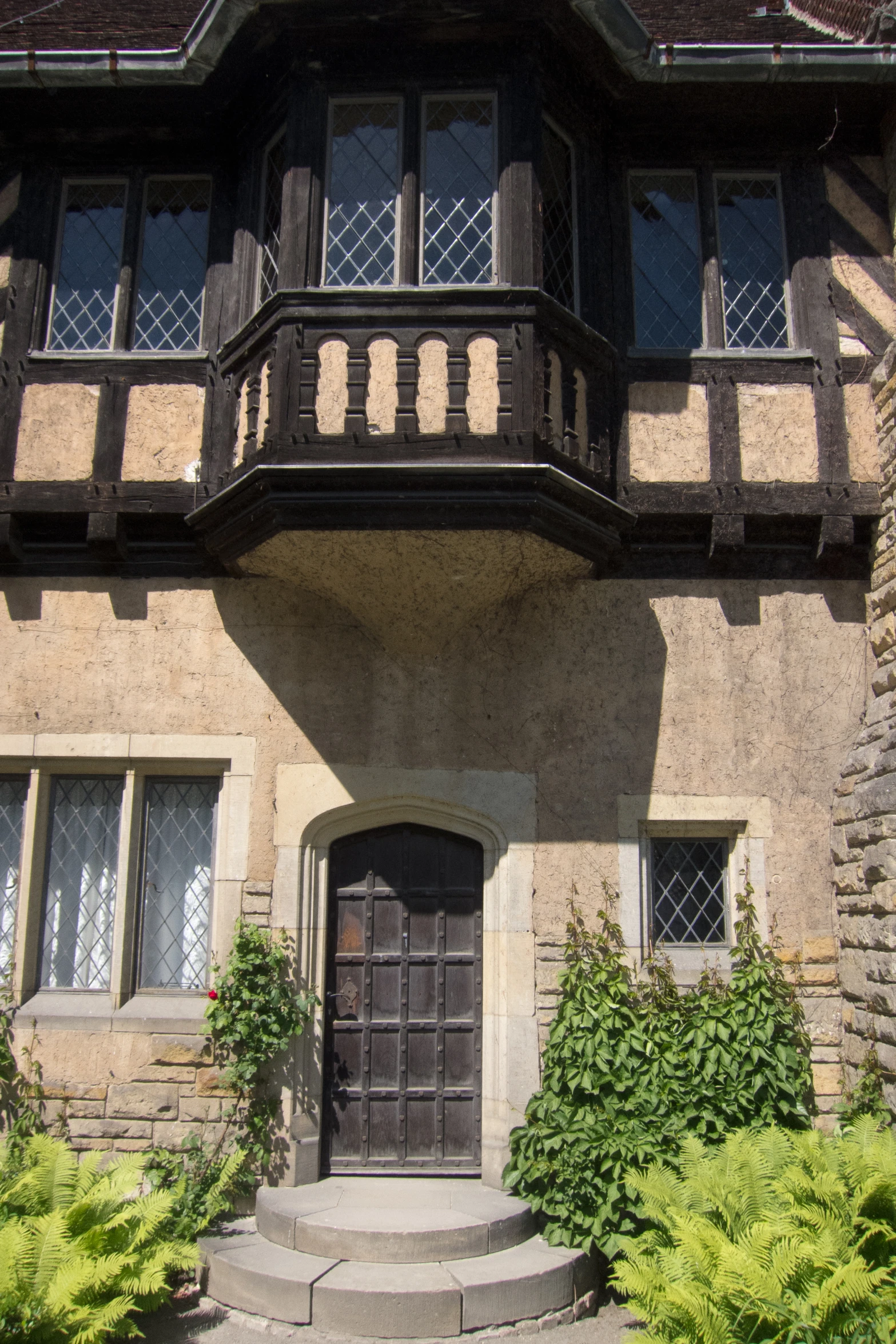 a building with a balcony, stairs and steps leading up