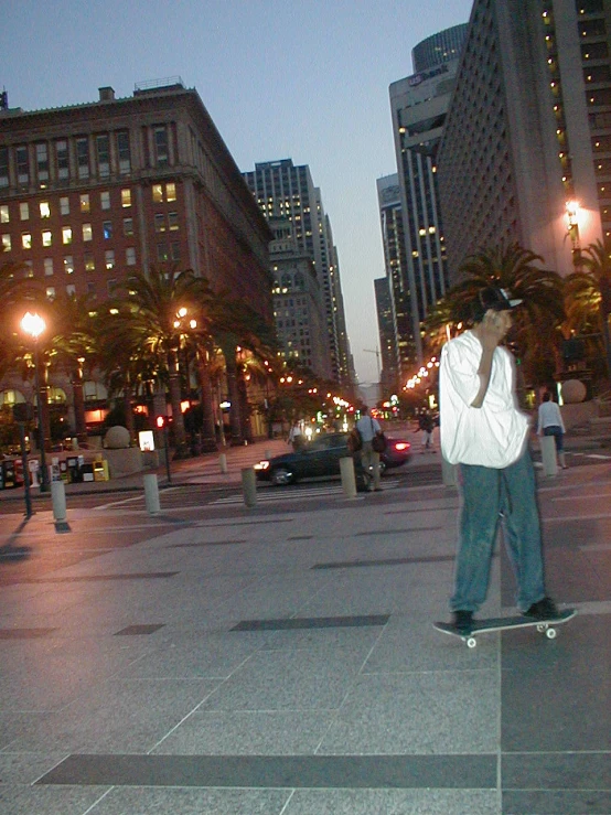 a man riding his skateboard down the middle of a sidewalk