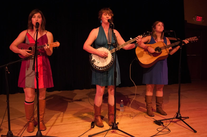 three women playing music instruments in the stage