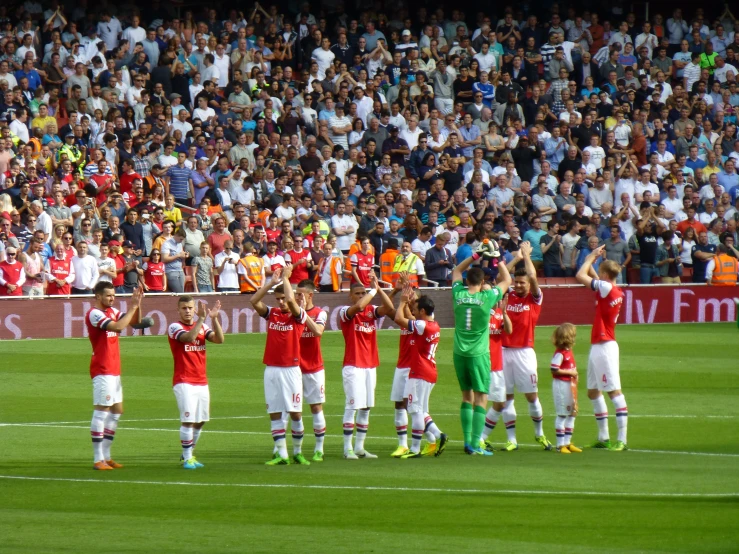 the soccer players are standing in a circle on the field