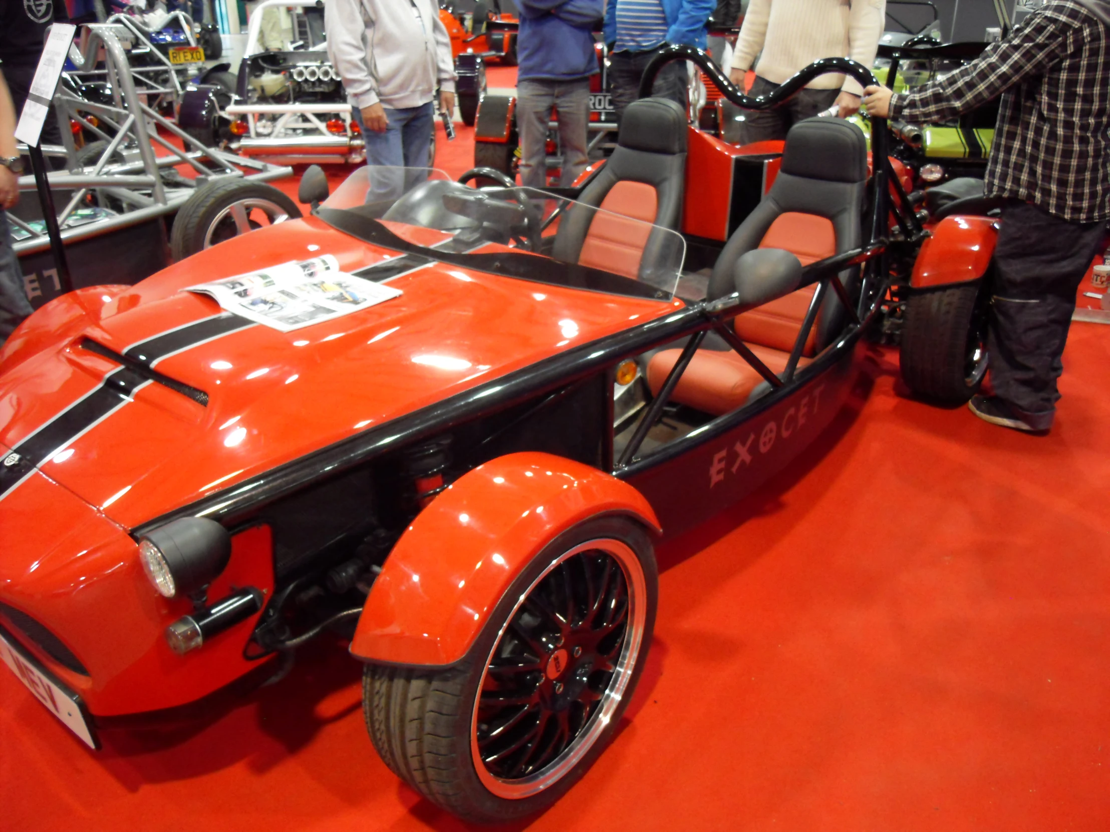 a big orange sports car that is on display