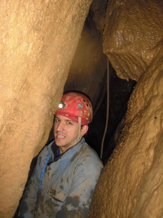 the man is sitting down inside a cave