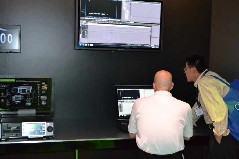 two men looking at some control displays inside