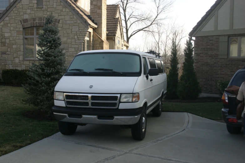 an all white van parked in a driveway