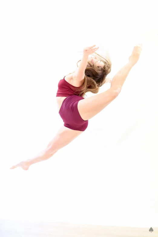 woman in red doing a gymnastics move with her feet off the ground