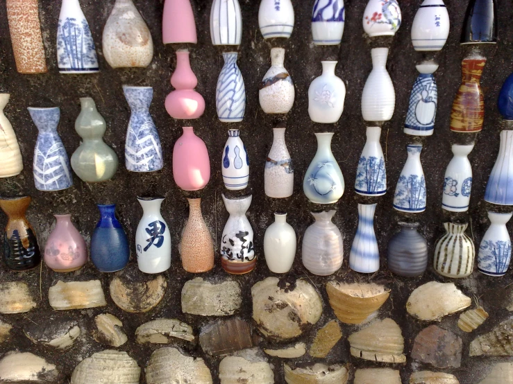 there are many small ceramic vases with designs